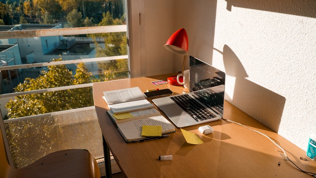 Desk with financial documents, laptop and charts used for research