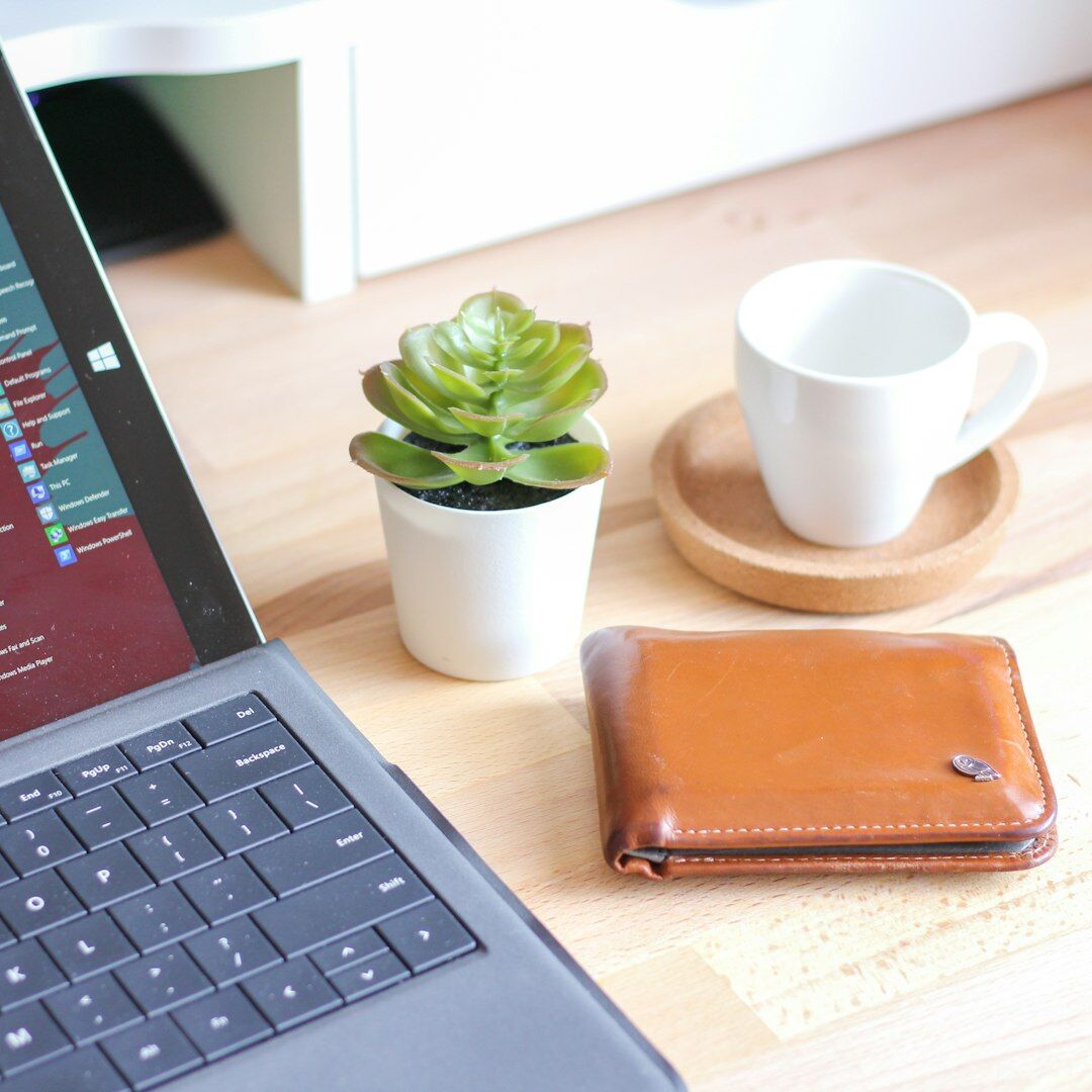 Overhead view of a desk with a laptop showing charts and a coffee cup